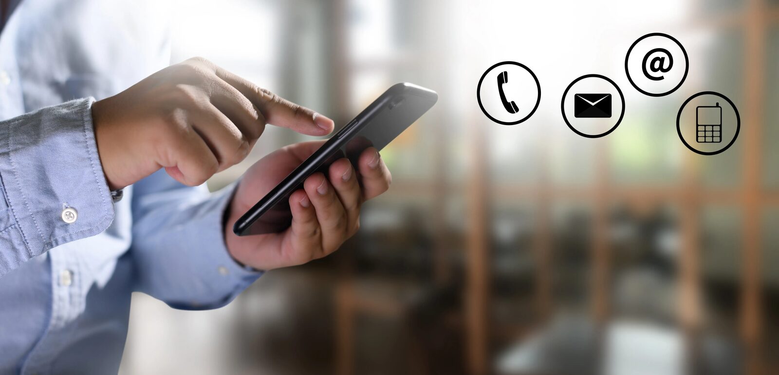 A person using a mobile phone, with call, email and message symbols alongside